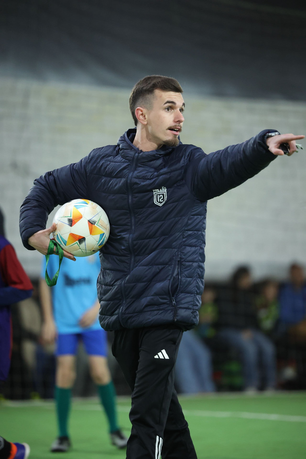 Professor do CT Falcão 12 orientando os alunos com a bola na mão